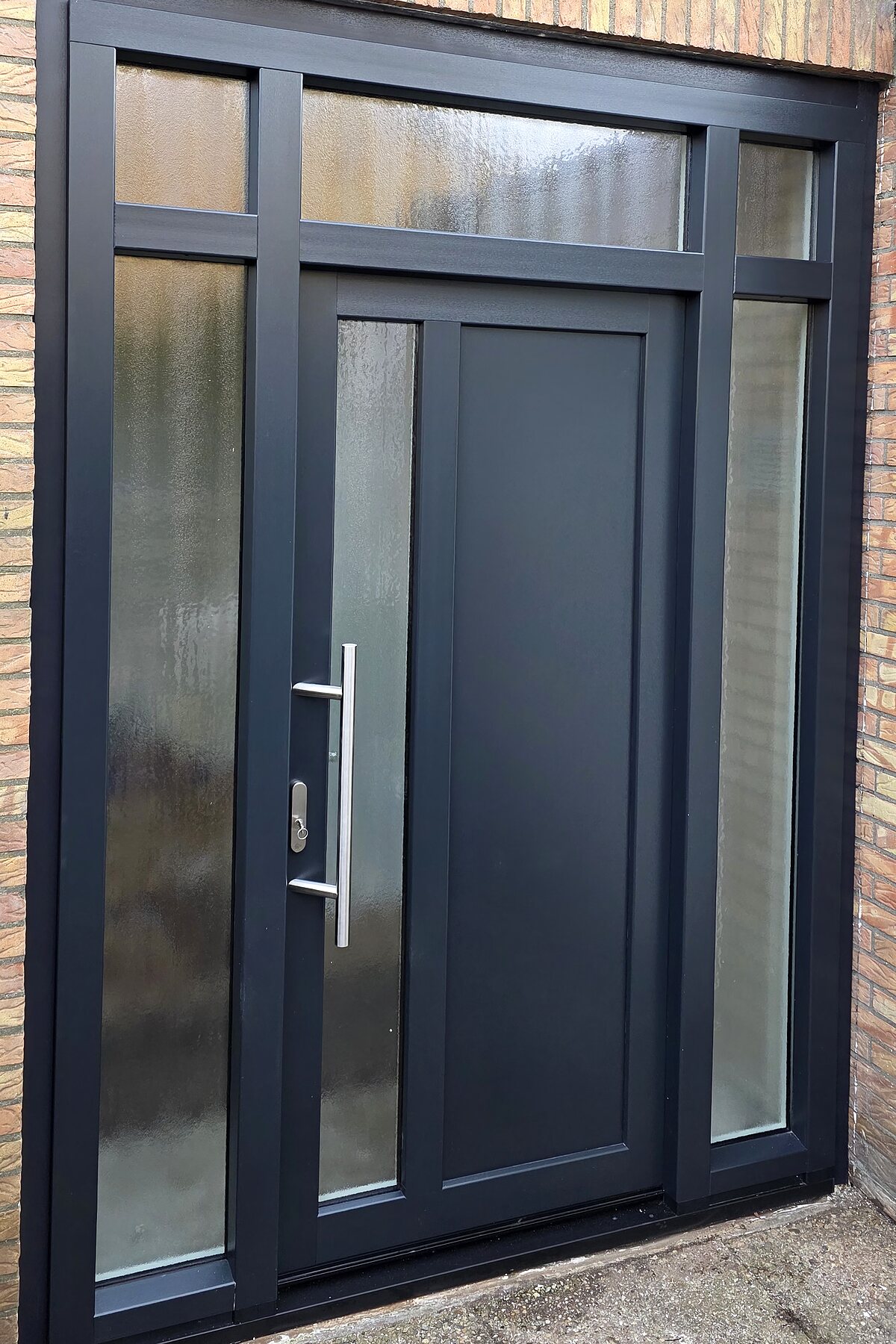 Door Groenwold Service geplaatste antraciete voordeur met zijlichten